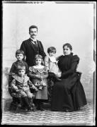 Ripresa in studio. Ritratto di gruppo: un uomo in piedi, una donna seduta e quattro bambini