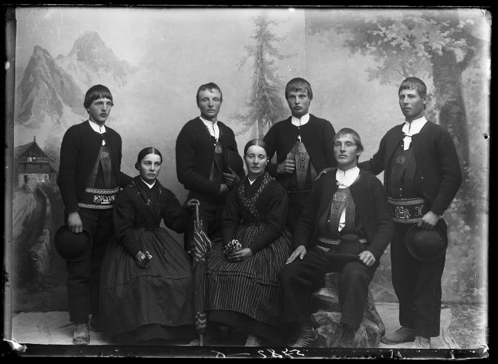 Studioaufnahme. Gruppenporträt, zwei Frauen und fünf Männer in Sarner Tracht. Zwei Frauen und ein Mann sitzen