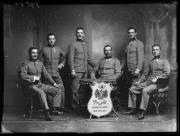 Ripresa in studio. Ritratto di gruppo di soldati in uniforme con una lavagna con l'iscrizione 