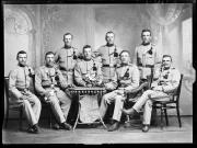 Ripresa in studio. Ritratto di gruppo di otto soldati in uniforme con una lavagna con l'iscrizione 