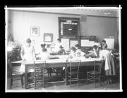 Ripresa interno. Aula con lezioni di cucito. Donne, sullo sfondo un cartello con la scritta 