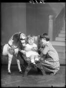 Studioaufnahme. Porträt eines Kindes auf einem Stuhl mit einer Frau