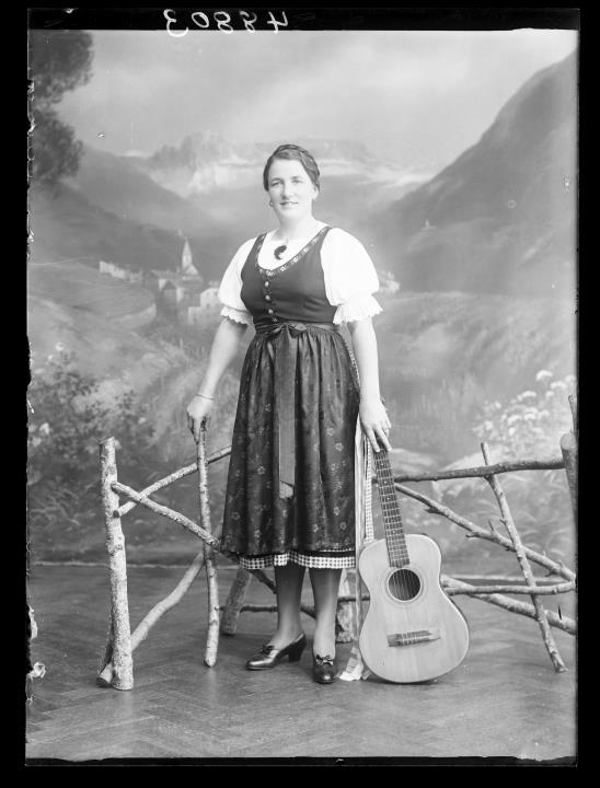 Studioaufnahme. Porträt einer Frau mit Gitarre. Information im Register (Nr. 7): Mair Maria