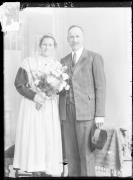 Ripresa interno. Ritratto di un uomo in piedi e una donna con un vestito tradizionale in piedi con un mazzo di fiori