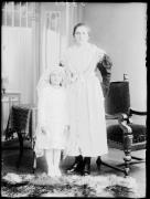 Ripresa in studio. Ritratto di gruppo di una donna in costume regionale in piedi e una bambina in abito da prima comunione. Informazione nel registro (n. 7): Wieser Barbara