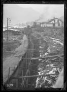 Ripresa in esterno. Cantiere e lavoratori. Costruzione della Lungotalvera di Bolzano, sullo sfondo un palazzo con la scritta 