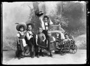 Ripresa in studio. Ritratto di gruppo con sei bambini con un carro rastrelliera e un cavallo giocattolo.