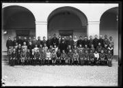 Ripresa in esterno. Ritratto di gruppo: un gruppo di studenti della Knabenschule con un maestro al centro. Un ragazzo tiene una cornice con la scritta 