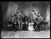 Ripresa in studio. Ripresa di gruppo: un gruppo di cinque soldati in uniforme, due di loro sono seduti con una spada. Al centro c'è una lavagna con la scritta 