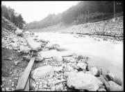 Ripresa in esterno. Scorrere di un fiume, binari, slavina di sassi, due uomini