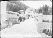 Ripresa in esterno. Strada di ghiaia, edificio con l'iscrizione 