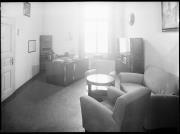 Ripresa interno. Camera con scrivania, sedie e una centralina elettrica/telefonica