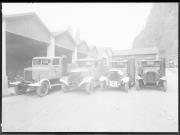 Ripresa in esterno. Quattro autocarri e un capannone con i numeri 