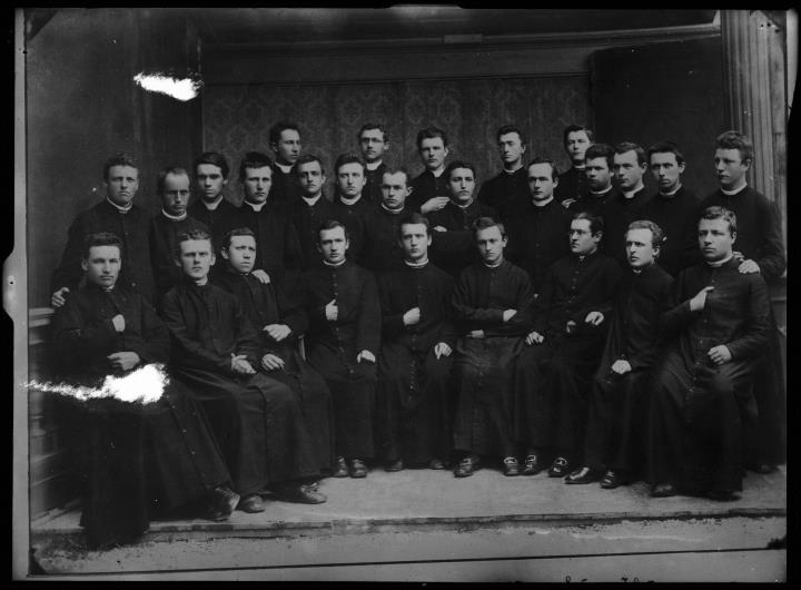 Studioaufnahme. Gruppenporträt von 27 Geistlichen, sitzend und stehend