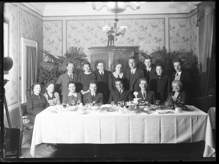 Ripresa interno. Ritratto di gruppo di sette donne e otto uomini a una tavola