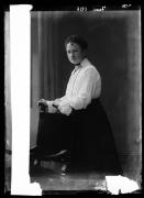 Ripresa in studio. Ritratto di una donn in piedi con una sedia