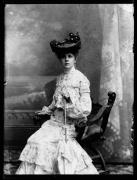 Ripresa in studio. Ritratto di una donna seduta von cappello e ombrello