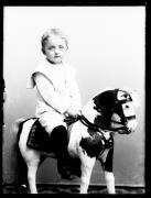 Ripresa in studio. Ritratto di un bambino con un cavallo da gioco