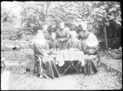 Ripresa in esterno. Ritratto di gruppo di un uome e sei donne, due di loro portano l'abito da suore, una anche una corona di fiori