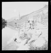 Ripresa in esterno. Ritratto di persona vestito in abiti tradizionali davanti va un lago. Sullo sfondo una chiesa