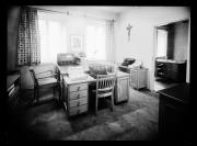 Ripresa interno. Molte scrivanie con macchine da scrivere e con i giornali Dolomiten e Volksbote