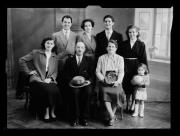 Ripresa interno. Ritratto di gruppo di tre uomini e di cinque donne. Una bambina ha una palla