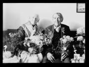 Ripresa interno. Una donna e un uomo con mazzi di fiori con una scritta 