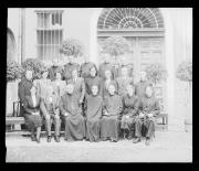 Ripresa in esterno. Ritratto di gruppo: donne e uomini, fra cui ecclesiastici