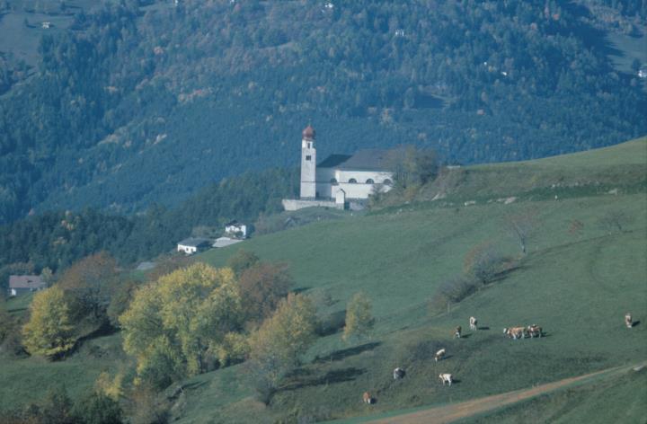 Aufnahme der Pfarrkirche (Hl. Laurentius und Hl. Stephanus) mit Höfen und Landschaft in Lajen
